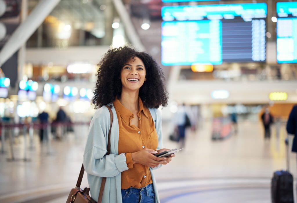 Black woman at airport, travel and passport with happiness, excited for holiday, plane ticket and boarding pass. Freedom, smile on face and flight with transportation, vacation mindset at terminal
