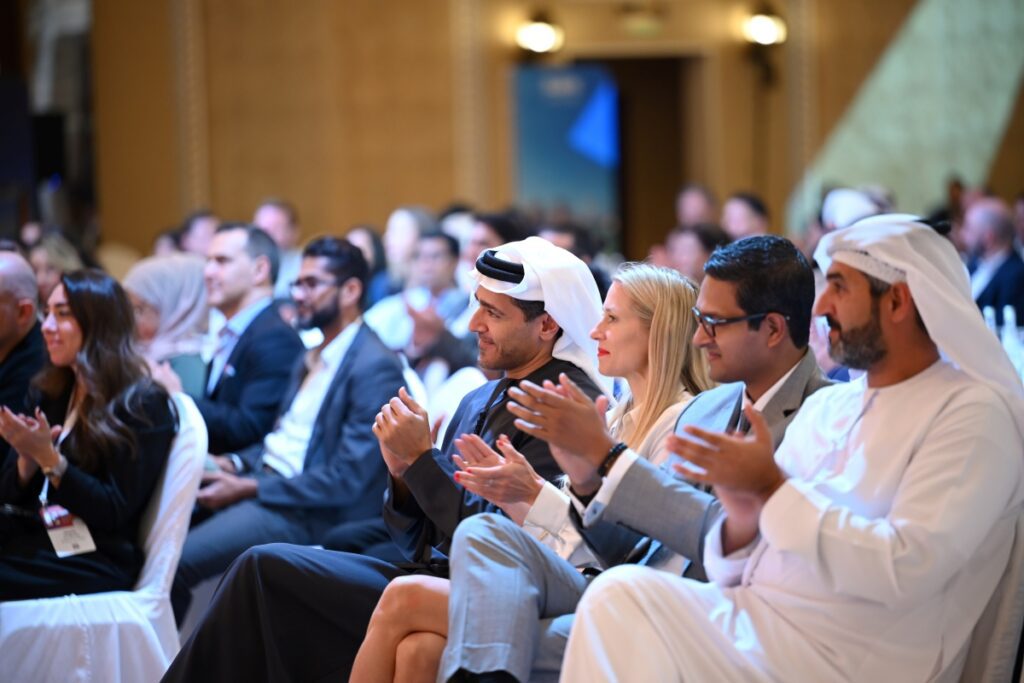 Skift Global Forum East 2022 audience full of attendees listening to live talks on stage in Dubai and clapping. 