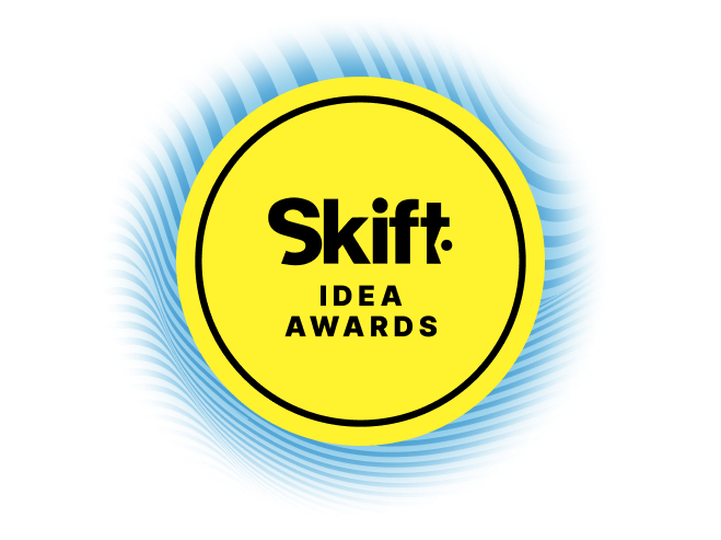 Yellow circular logo for Skift IDEA Awards with blue blur shadow