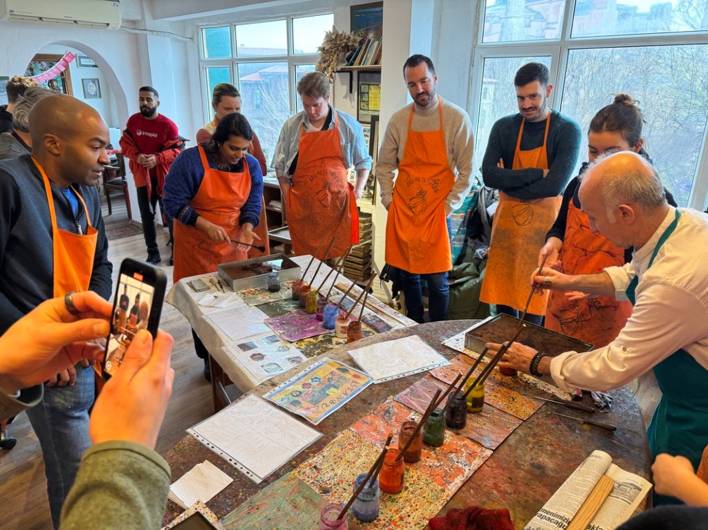 Skift team members get creative at a traditional marbling workshop, reflecting the spirit of innovation celebrated at the Skift IDEA Awards.